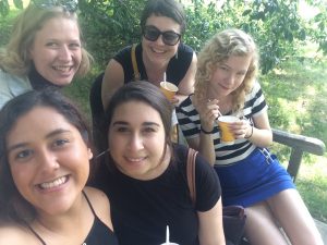 photo of five women on bench enjoying water ice